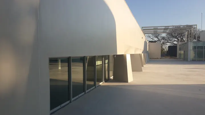 Galeria envidraçada sob fachada branca curva