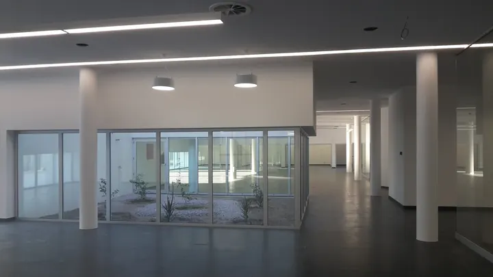 Interior com pilares brancos e pátio envidraçado