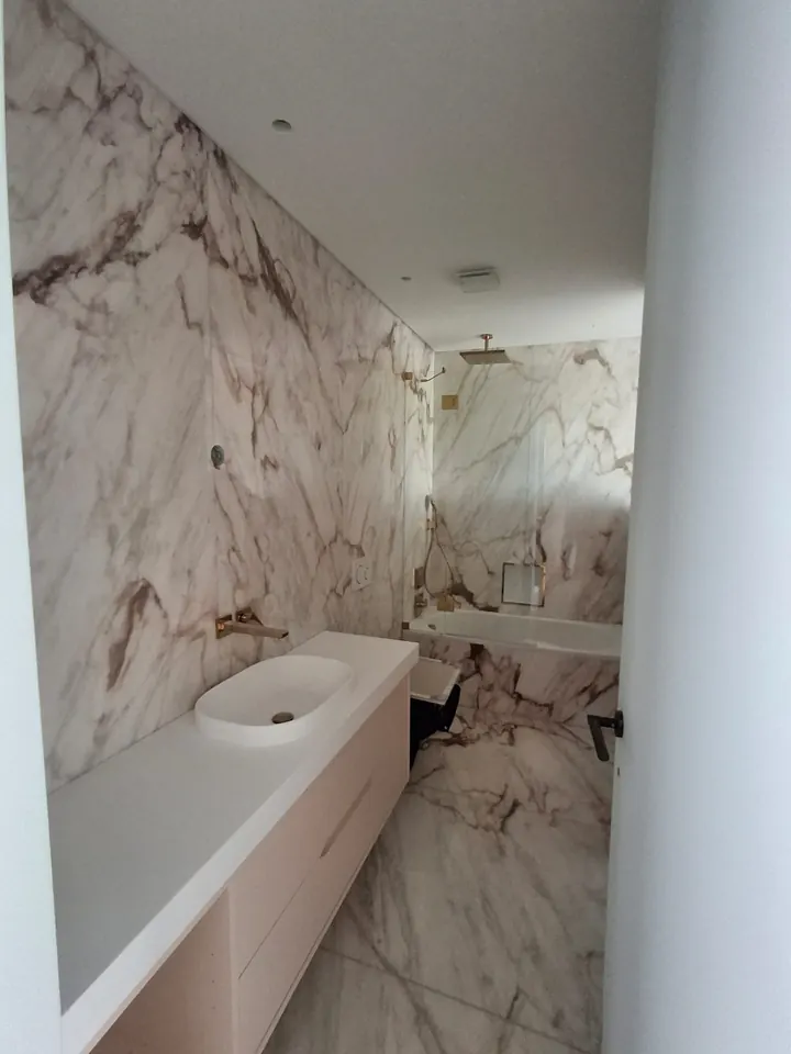 Casa de banho revestida a mármore branco com veios
